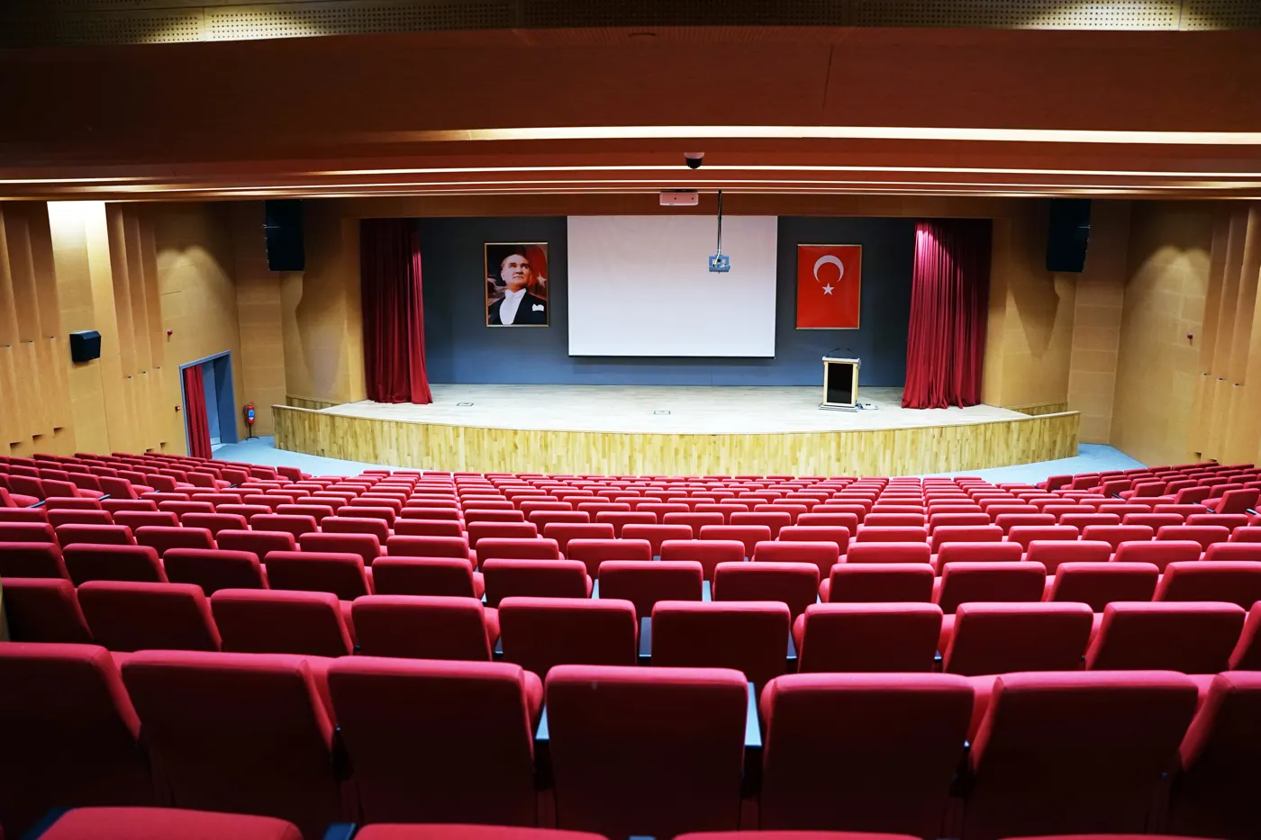 Auditorium mit roten Sitzen und Holzbühne